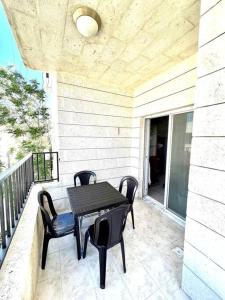 eine Terrasse mit einem Tisch und Stühlen auf dem Balkon in der Unterkunft Cozy 3 Bedroom Apartment Near 7th Circle in Amman