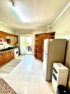a kitchen with a refrigerator and a tile floor at Cozy 3 Bedroom Apartment Near 7th Circle in Amman