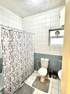 a bathroom with a toilet and a shower curtain at Cozy 3 Bedroom Apartment Near 7th Circle in Amman