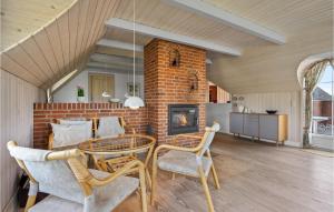 a living room with a brick fireplace and a table and chairs at 3 Bedroom Amazing Home In Ringkbing in Ringkøbing
