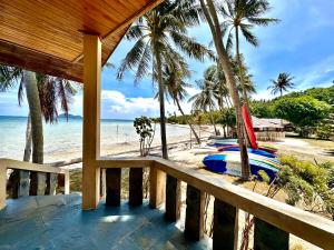 a balcony of a resort with a beach with a surfboard at Beck's Resort in Haad Pleayleam