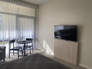a hotel room with a television and a table and chairs at Toronto Hotel in Toronto