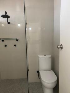 a bathroom with a toilet and a glass shower door at Toronto Hotel in Toronto