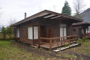 a small wooden cabin with a porch and a porch at Ruca del Fuy in Panguipulli