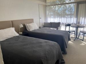 1 dormitorio con 2 camas, sofá y mesa en Toronto Hotel en Toronto