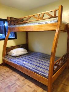 Ce lit se trouve dans un dortoir doté de 2 lits superposés et d'un matelas bleu. dans l'établissement Hondelz Budget Homestay, à Busuanga