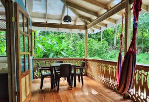 a porch with a table and chairs on it at Casa Siri de Cahuita in Cahuita