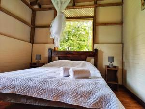 1 dormitorio con 1 cama con 2 toallas en Casa Siri de Cahuita, en Cahuita