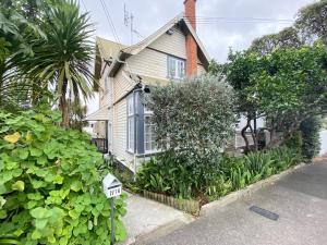 a house with a sign in front of it at 1920s Classic Cozy 2-Bedroom Villa Apartment in Parnell in Auckland