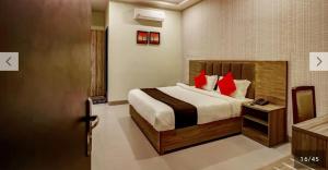 a bedroom with a bed with red pillows at Hotel Sindhura Grand in Hyderabad