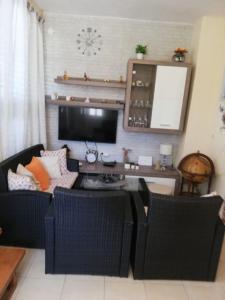 uma sala de estar com duas cadeiras e uma televisão em Apartment Josip - 5 m from beach em Vinišće