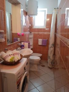 uma casa de banho com um lavatório, um WC e uma janela. em Apartment Josip - 5 m from beach em Vinišće