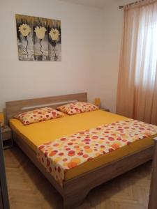 um quarto com uma cama com um edredão amarelo em Apartment Josip - 5 m from beach em Vinišće
