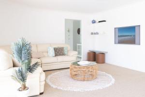 a living room with a couch and a coffee table at Bokarina Seaside Escape - Only steps to the Beach in Kawana Waters