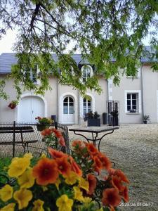 a house with a table and flowers in front of it at VILLA ESPERANZA Chambre 2 proche Zoo de Beauval et Châteaux de La Loire in Valençay