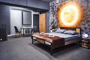 a bedroom with a large bed with a painting on the wall at Gagarin Capsule Hotel in Almaty