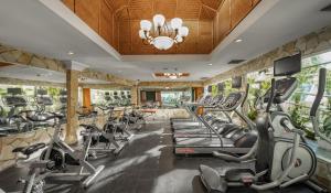 a gym with a row of treadmills and ellipticals at Fortuna Hotel Hanoi in Hanoi