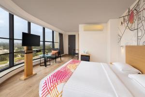 a hotel room with a bed and a flat screen tv at Ginger Ahmedabad RTO Circle in Ahmedabad