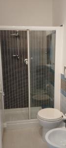 a bathroom with a toilet and a glass shower at L'angolo degli ulivi in Marcellano