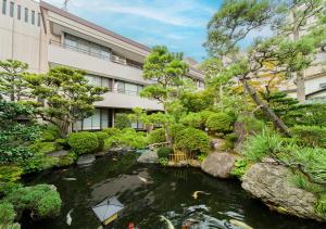 einen Garten mit einem Teich vor einem Gebäude in der Unterkunft Haiya in Awara