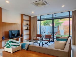 - un salon avec un canapé et une télévision dans l'établissement Merissa Luxury Private Pool Villa, à Pantai Cenang