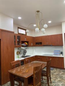 a kitchen with a wooden table and wooden cabinets at Upla Homestay in Vung Tau