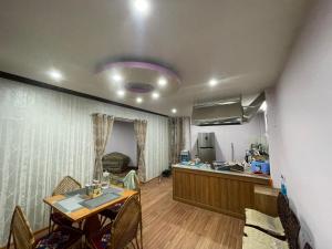 uma sala de estar com uma mesa e uma cozinha em Dzambala Home em Kathmandu