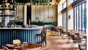 a restaurant with tables and chairs and a bar at Bannisters Port Stephens in Soldiers Point