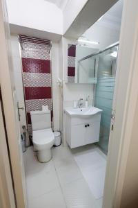 a white bathroom with a toilet and a sink at Fidelya Boutique Hotel in Istanbul