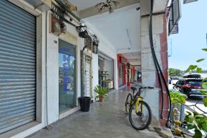 a bike parked on a sidewalk in front of a building at OYO 90794 Maple Hotel in Skudai