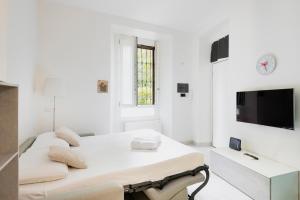 uma sala de estar branca com um sofá e uma televisão em Easylife - Comodo Studio in Corso di Porta Romana em Milão
