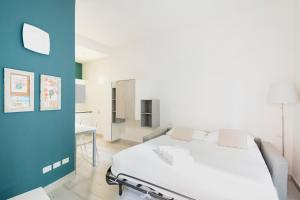ミラノにあるEasylife - Comodo Studio in Corso di Porta Romanaのベッドルーム1室(白いベッド1台、青い壁付)