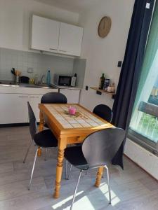 einen Holztisch mit vier Stühlen in einer Küche in der Unterkunft studio parking privé climatisation plage proche in La Grande-Motte