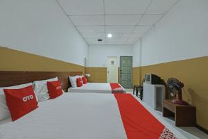 a hotel room with two beds and a tv at OYO 90794 Maple Hotel in Skudai