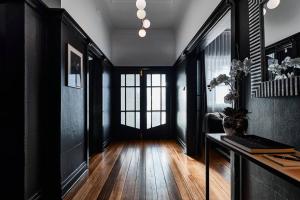 a hallway with black walls and a desk in a room at Ruby by Whiskey June in Maryborough