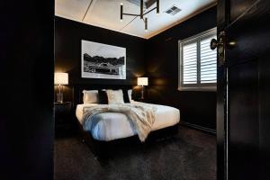 Dormitorio negro con cama y ventana en Ruby by Whiskey June, en Maryborough