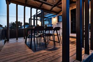 a patio with a table and chairs on a deck at Ruby by Whiskey June in Maryborough