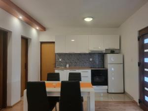 a kitchen with a table and chairs and a refrigerator at Apartments Lola in Biograd na Moru