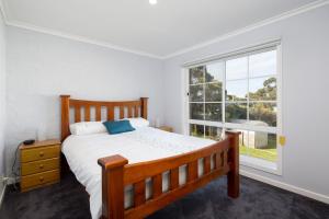 una camera da letto con un letto e una grande finestra di Seaside Retreat in Rhyll a Rhyll