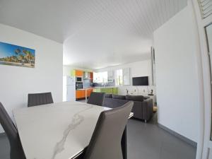 cocina y sala de estar con mesa blanca y sillas en KORN LAMBIS, en Sainte-Luce