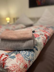 una pila de toallas sentadas encima de una cama en Im Grünen von Kiel, en Kiel