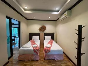 two beds sitting next to each other in a room at สงขลาคีรี รีสอร์ท SongkhlaKeeree Resort in Ban Khao Rup Chang