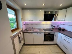 a kitchen with white cabinets and a sink and a window at Bähnleblick Blumberg in Blumberg