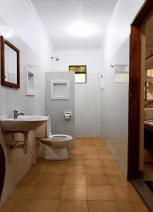a bathroom with a toilet and a sink and a shower at Shamba Hostel in Usa River