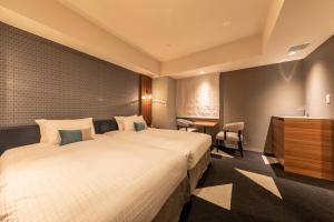 a hotel room with a large bed and a desk at Tokyu Stay Sapporo Odori in Sapporo
