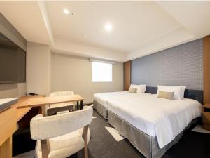 a hotel room with two beds and a desk and a television at Tokyu Stay Sapporo Odori in Sapporo