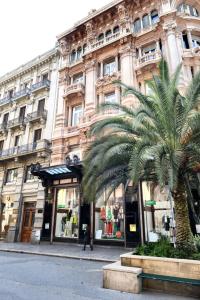 duży budynek z palmą przed nim w obiekcie B&B Sparano Luxury Suites w mieście Bari