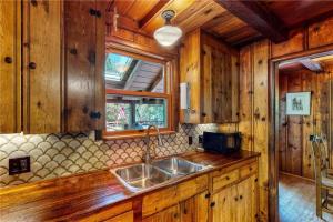 una cocina con fregadero en una cabaña de madera en Cabin Spa Getaway Near Lakes and Resorts, en Crestline