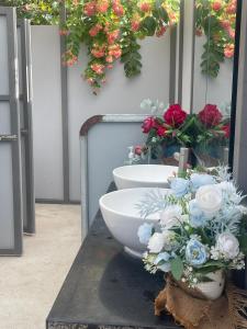 a bathroom with a sink and flowers on a table at Suối Đá F-Glamping in Ấp Long Lâm
