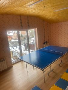 eine blaue Tischtennisplatte in einem Zimmer in der Unterkunft Коттедж У Анютки in Truskawez